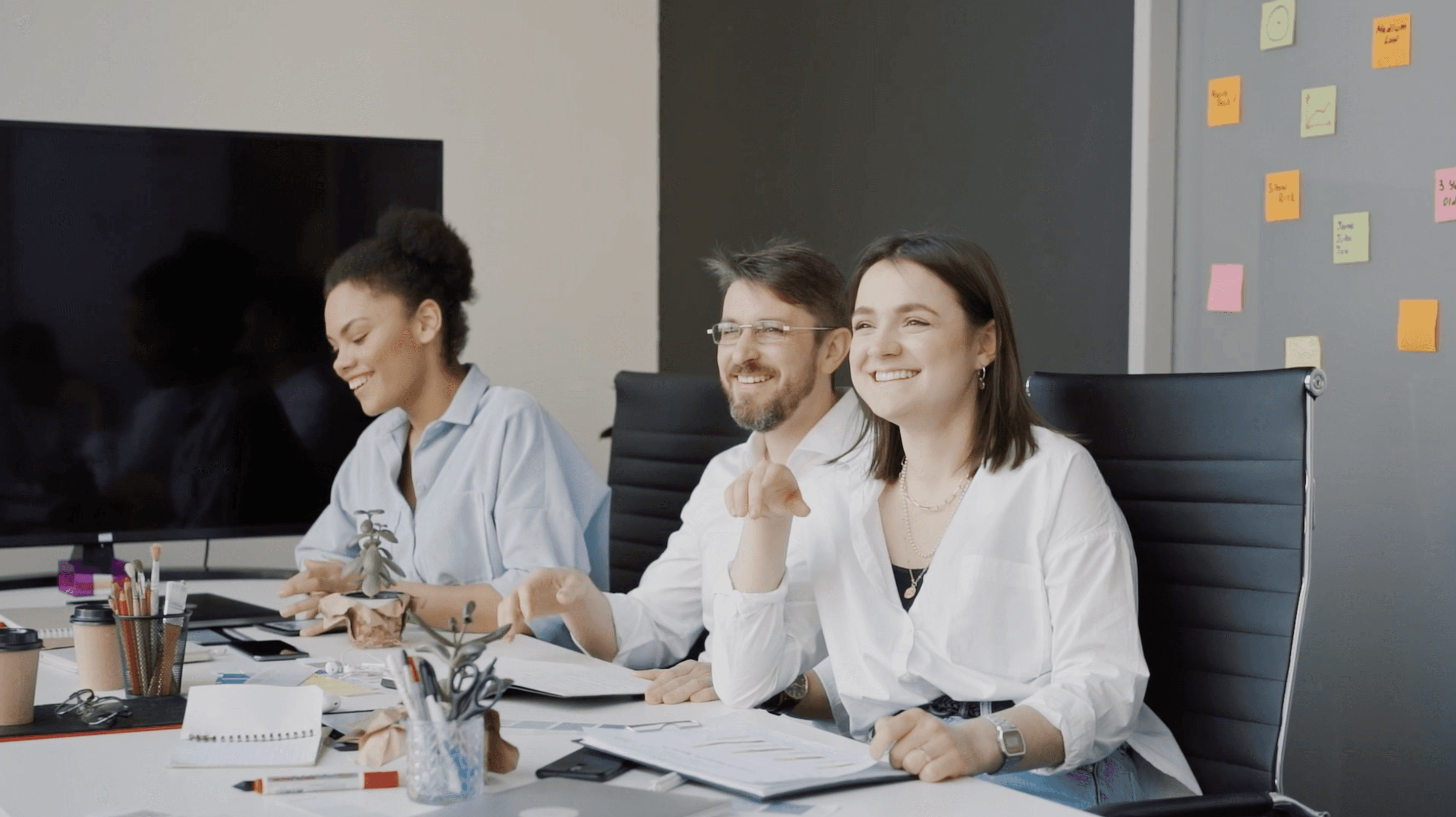 About hero — team smiling around a table