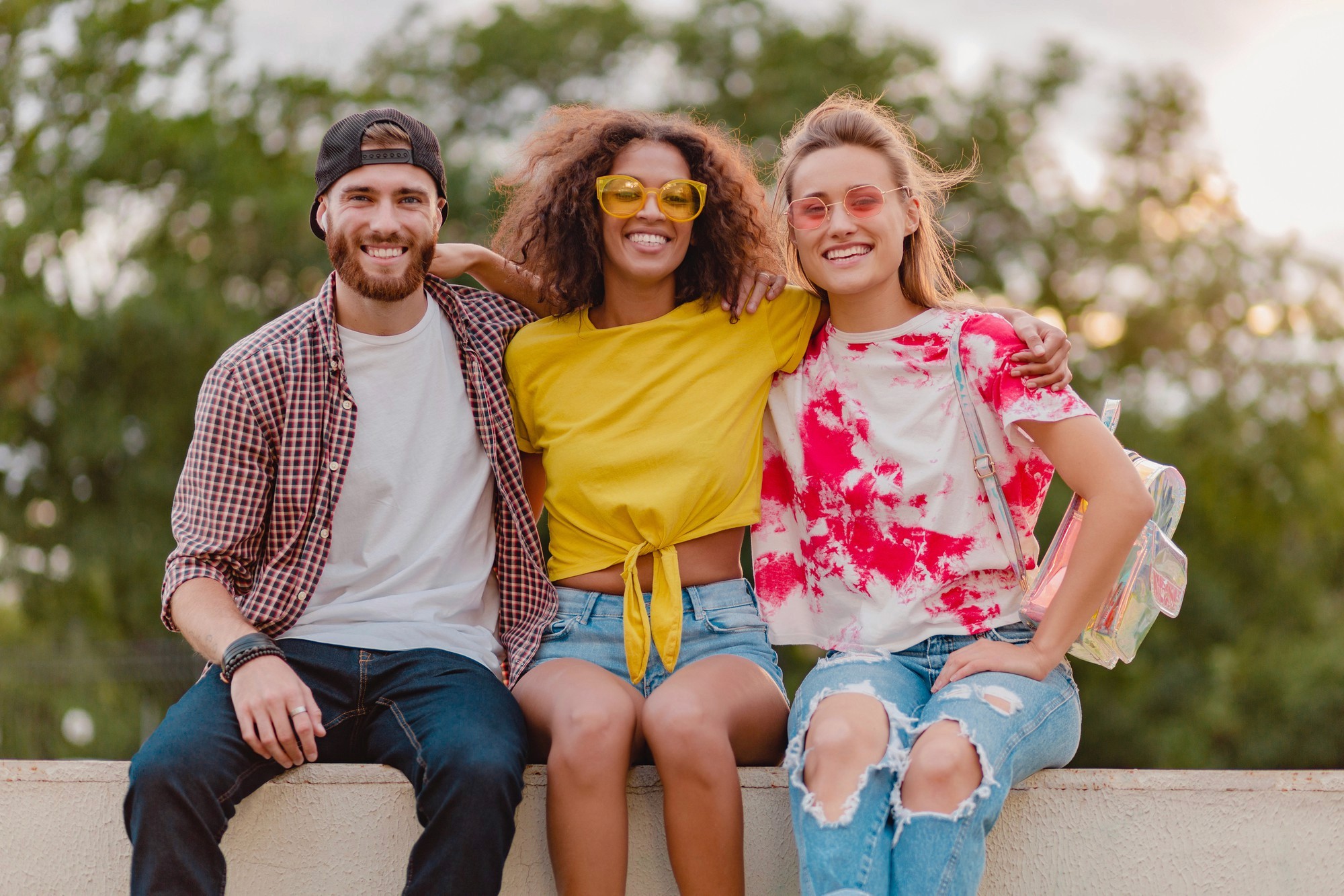 Band — three friends outdoors, arms around each other